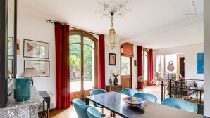 A dining area with a marble table, blue chairs, and a chandelier. - Superb architect-designed villa in Fontainebleau -1h from Paris (Larchant)