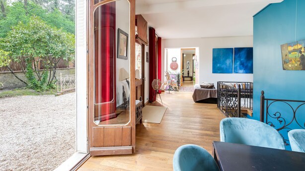 A room with a wooden floor, a dining area with a table and chairs, and a view of the outdoors. - Superb architect-designed villa in Fontainebleau -1h from Paris (Larchant)