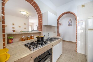 Réfrigérateur, un four, surface de cuisson, vaisselle et ustensiles