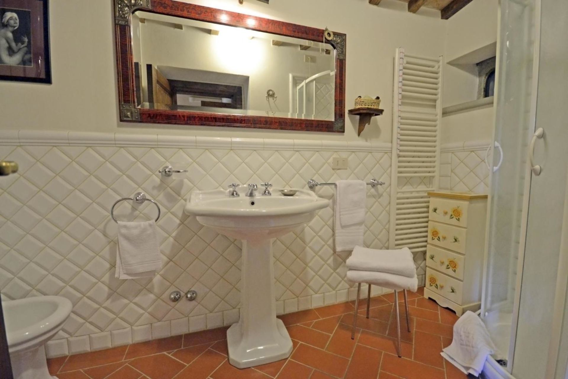 Ein Badezimmer mit einem Standwaschbecken, einer Toilette und einem Waschtisch mit Schubladen.