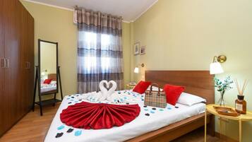 Una camera d'albergo con un letto, un comodino, uno specchio, una finestra con tende e un armadio in legno.