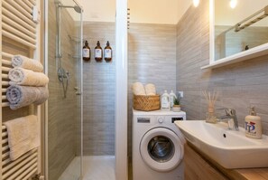 Chuveiro, secador de cabelo, toalhas de banho, shampoo