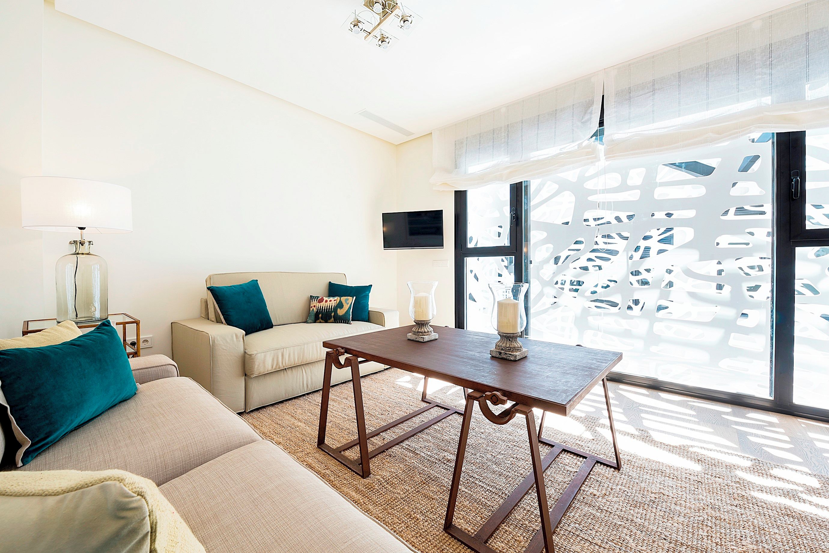 Un salon moderne avec un canapé, une table basse et un téléviseur fixé au mur.