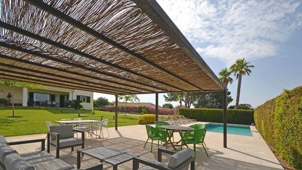 An outdoor patio area with a pool, seating, and a covered section with a thatched roof. - Ses Nines - Charming country house with pool in Inca, Mallorca (Inca)