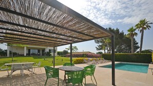 An outdoor patio with a pool, green chairs, and a covered area with a pergola. - Ses Nines - Charming country house with pool in Inca, Mallorca (Inca)