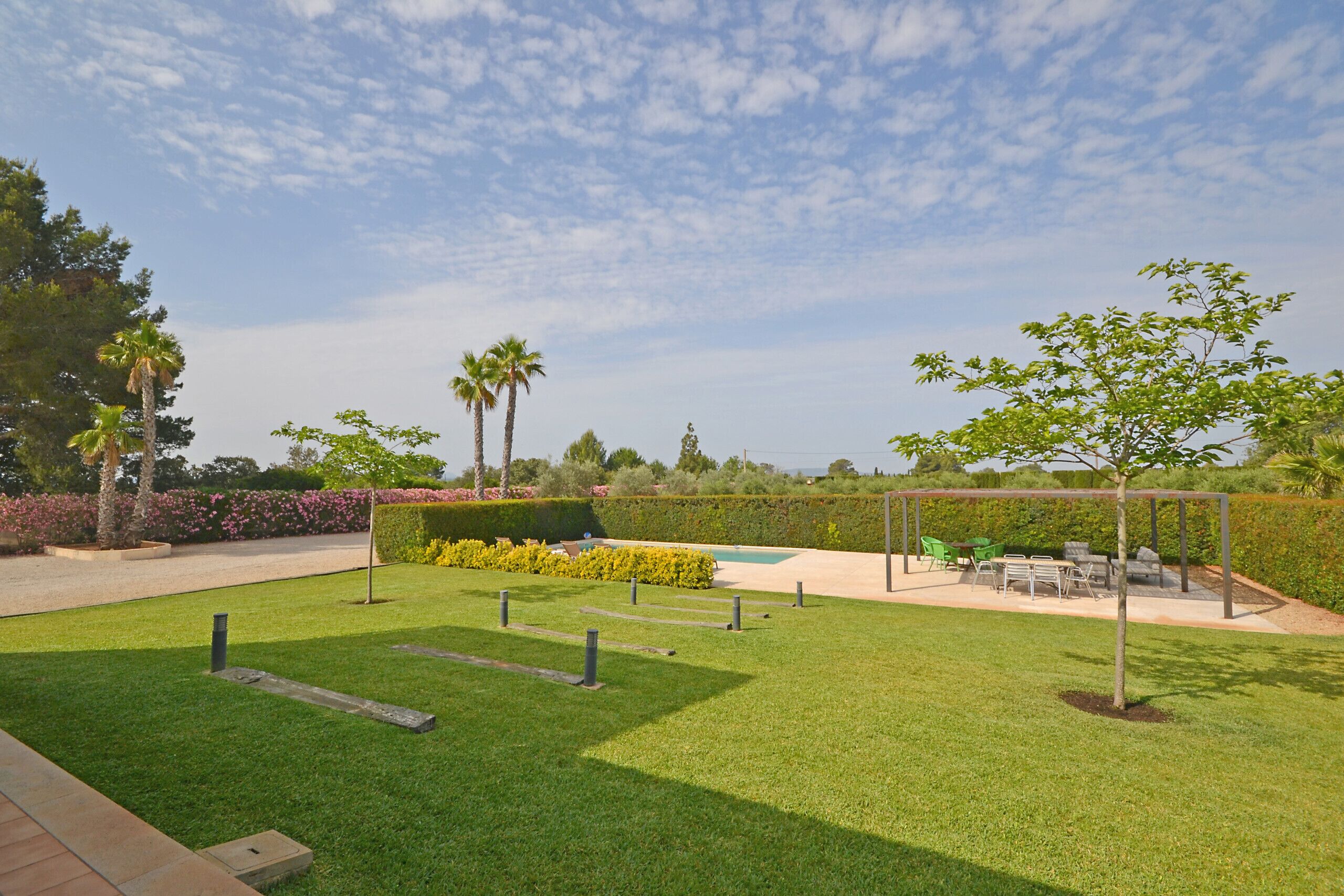 A well-maintained outdoor area with a pool, seating, and greenery.