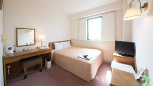 A hotel room with a bed, a desk with a telephone and lamp, a television, and a window with natural light. - Smile Hotel Oita Hita (Hita)