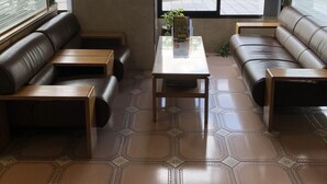 A modern interior with leather sofas, a central table, and patterned floor tiles. - Smile Hotel Oita Hita (Hita)