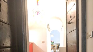 A hallway with a wooden floor, a red wall, and a door with a 'WELCOME' mat. - Via Crispi Spanish Steps Apartment. New right in the central elegant and quiet (Roma)