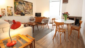 A modern living room with a sofa, a red desk lamp, a coffee table, and a dining area with chairs and a table. - Via Crispi Spanish Steps Apartment. New right in the central elegant and quiet (Roma)