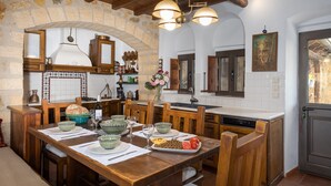 Une cuisine rustique avec des murs en pierre, des meubles en bois et un mur recouvert de carreaux.