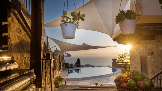 Une terrasse avec une piscine, des plantes en pot et un panier de fruits.