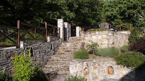 A stone staircase leading up to a stone wall with a wooden fence.
