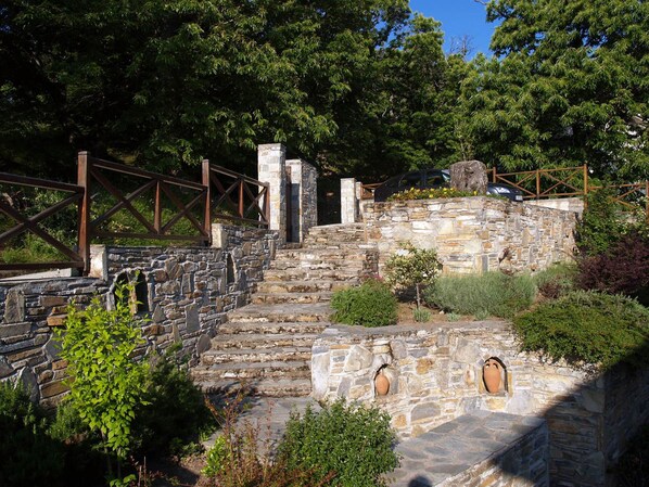 A stone staircase leading up to a stone wall with a wooden fence.