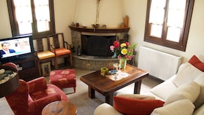 A cozy living room with a fireplace, comfortable seating, and a television.