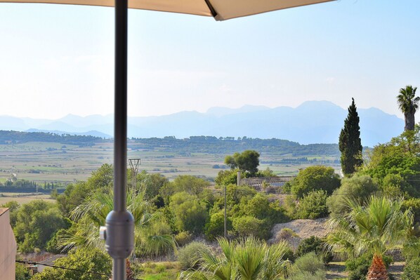 A terrace with a view of rolling hills and distant mountains.