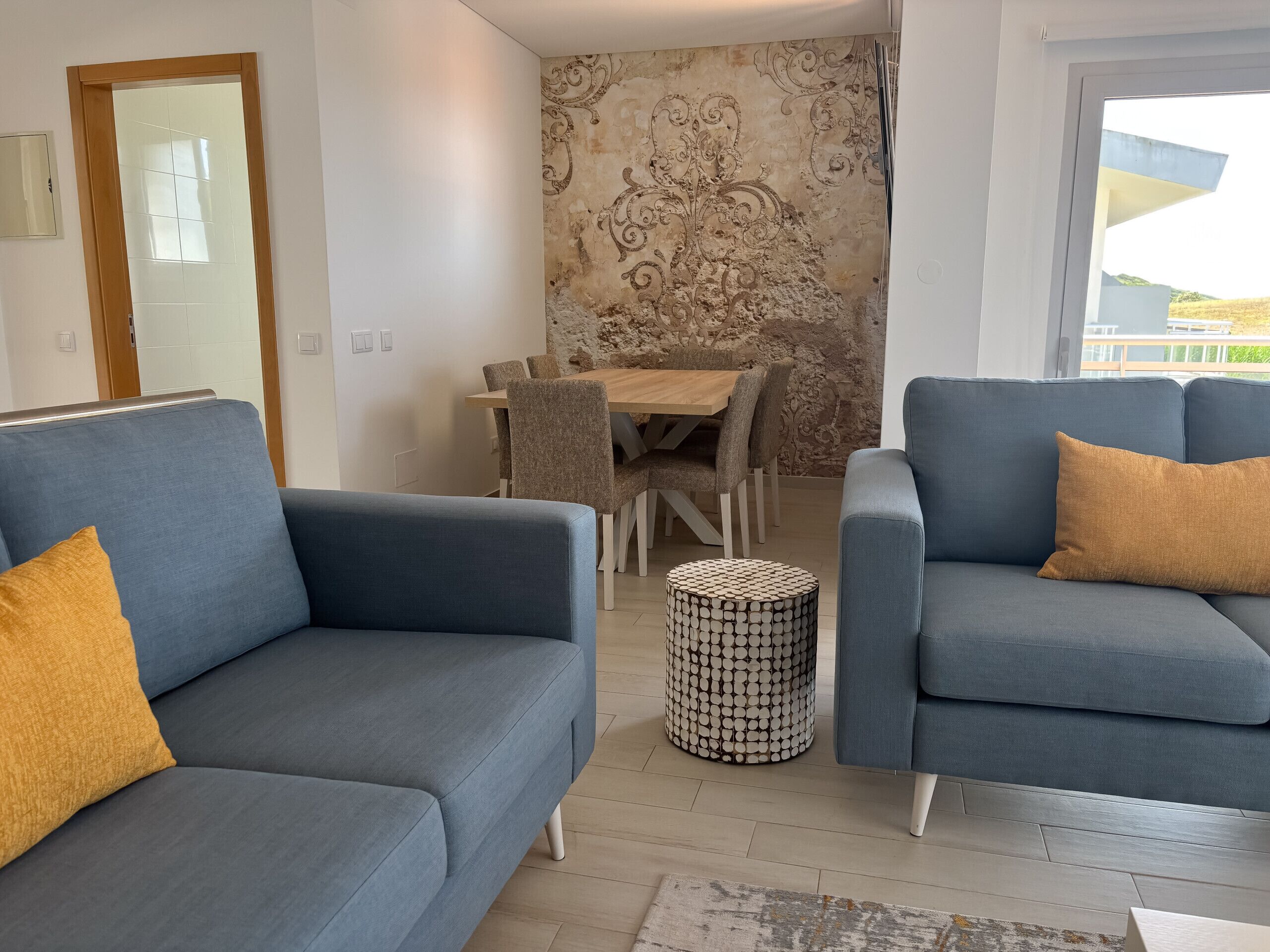 A modern living room with two sofas, a dining table, and chairs.