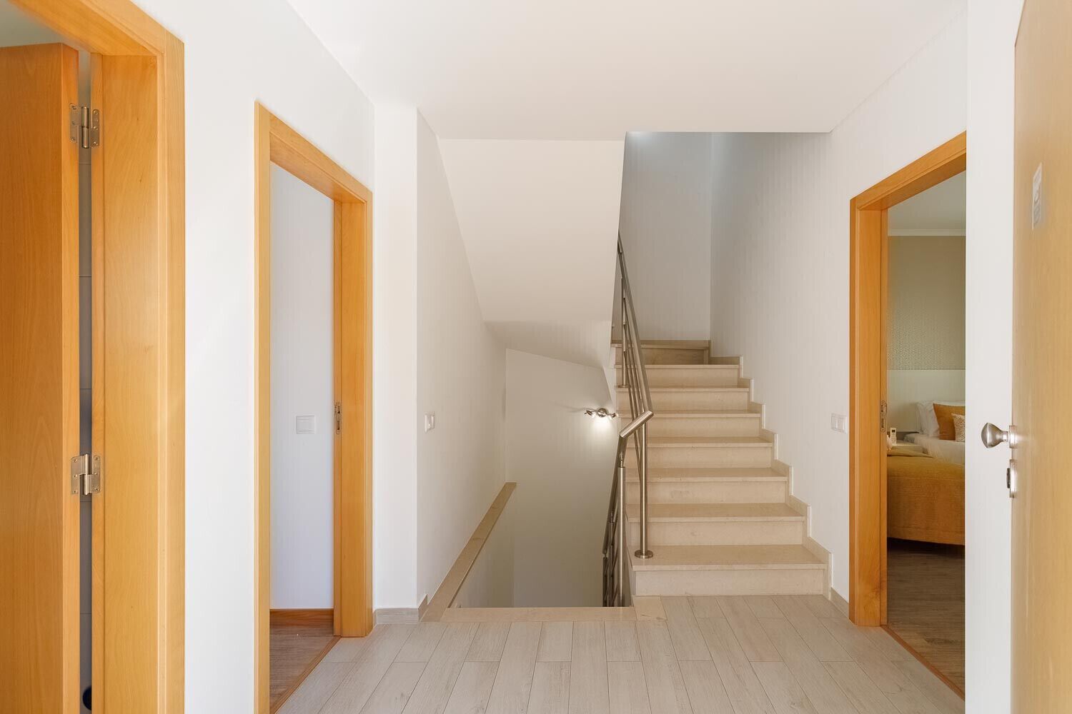 Una escala amb portes de fusta a banda i banda que condueix a una habitació.