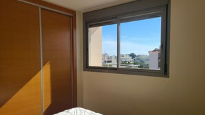 Un dormitorio con cama, ventana y armario de madera.