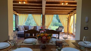 Un coin repas avec une table dressée pour quatre personnes, un canapé et une vue sur l’extérieur.