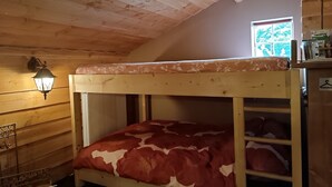 A bunk bed with a floral-patterned top bunk and a red and white patterned bottom bunk. - Romantic Cottage; hier kom je tot rust! (Ulft)