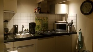 A kitchen with a sink, stove, microwave, and various appliances. - Romantic Cottage; hier kom je tot rust! (Ulft)