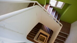 Una escalera con barandilla blanca y un pequeño ventanal en la parte superior.