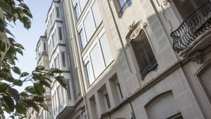 A multi-story building with classical architecture, featuring symmetrical windows and ornate details.