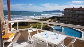 Ein Balkon mit Meerblick, ein Pool und ein Gebäude mit Balkonen.
