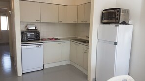 Een koelkast, een magnetron, een kookplaat, een vaatwasser