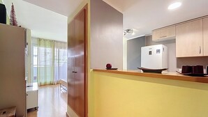 Eine Küche mit Kühlschrank, einer Holzauslage und einer Tür zu einem anderen Raum.