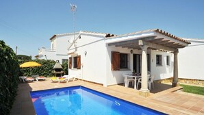 A poolside area with a clear blue pool, white walls, and a pergola. - -Villa with private swimming-pool. HUTG-001429 (l'Escala)