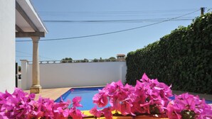 A pool area with a blue pool, surrounded by a white wall and a green hedge. - -Villa with private swimming-pool. HUTG-001429 (l'Escala)
