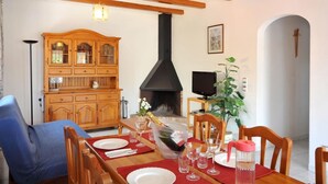 A dining area with a wooden table set for six, a wooden cabinet, a black stove, a television, and a plant. - -Villa with private swimming-pool. HUTG-001429 (l'Escala)