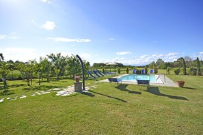 A pool area with lounge chairs and a small pool.