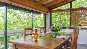 A wooden dining table set with plates, glasses, and a decorative vase.