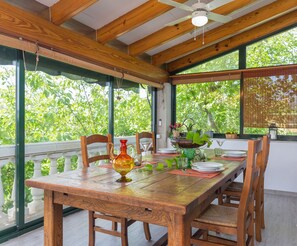 A wooden dining table set with plates, glasses, and a decorative vase. - Can Marti - Wonderful villa with pool in a mountain area near Alcúdia (Alcúdia)