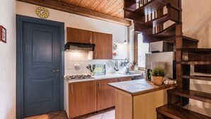A kitchen with wooden cabinets, a stove, and a sink. - Villa Collebelvedere - Apartment West - Home Restaurant (Fara Sabina (RI))