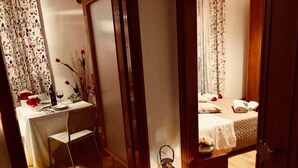 Una habitación con cama, escritorio y espejo.