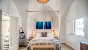 A bedroom with a four-poster bed, a painting above the bed, and a view of the outside through a window. - Il Nido - Le Case di Valentina (Gallipoli)