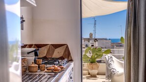 A kitchen with a grill, pots, and a view of the sea. - Il Nido - Le Case di Valentina (Gallipoli)