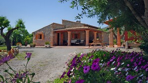 A rustic stone building with a patio and outdoor seating area. - Can Roig 113 fantastic finca with private pool, garden, children's area and air-conditioning (Alcúdia)