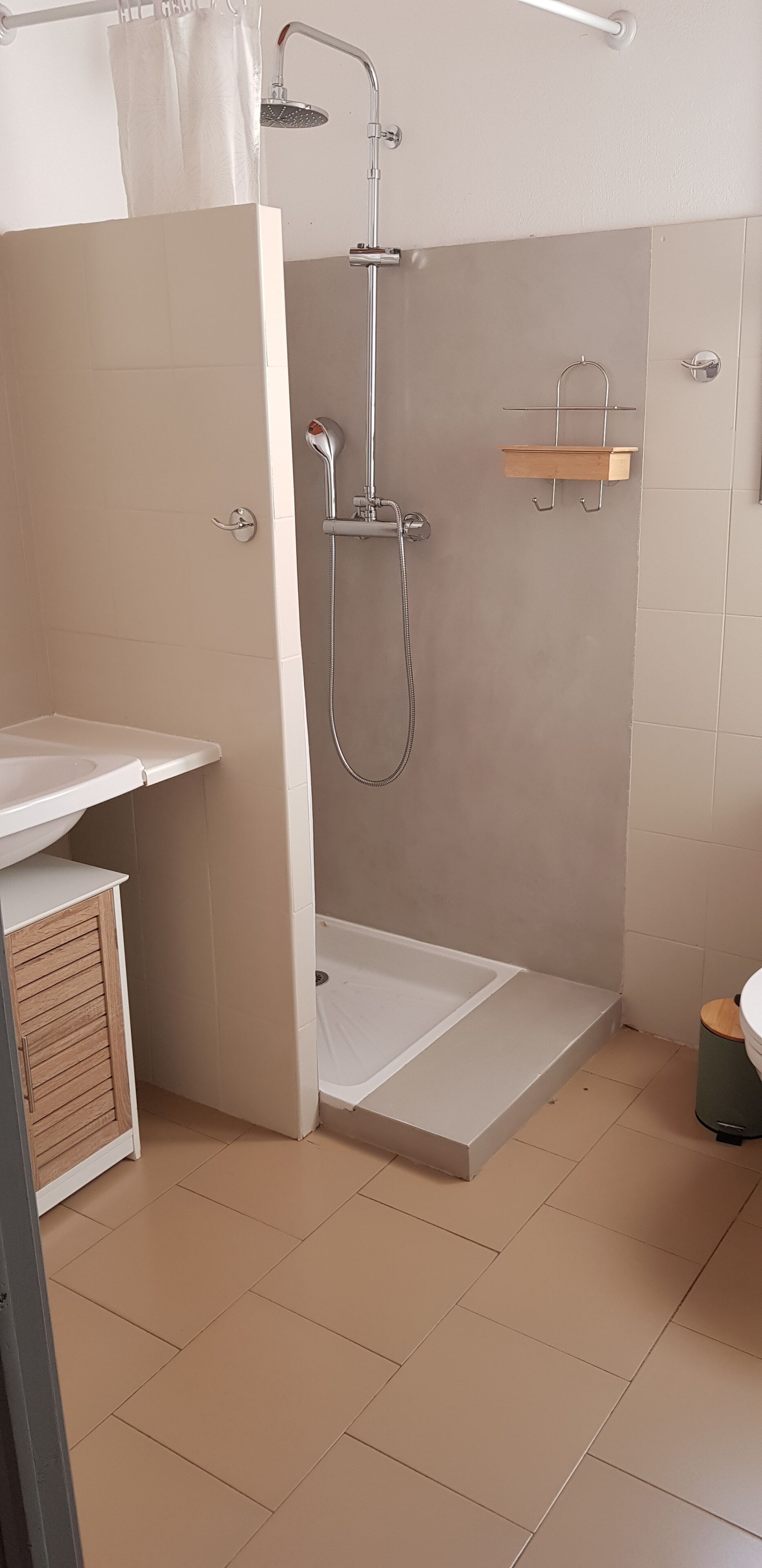 A modern bathroom with a shower, a toilet, and a sink.