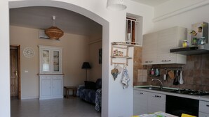 Una cocina compacta con comedor, horno empotrado y lavamanos.