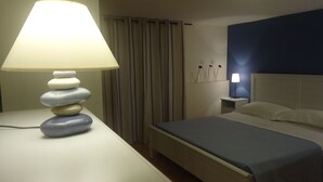 A hotel room with a bed, a bedside table with a lamp, and a nightstand with a lamp. - Ortigia, comfortable Baron house (Siracusa)