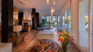A modern living room with a fireplace, a sofa, a coffee table, and a view of the outdoors. -  Beautiful sunny villa with pool and sea views Marbella (ELVIRIA) (Marbella)