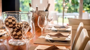 A dining table set with plates, glasses, and a bowl of decorative balls. -  Beautiful sunny villa with pool and sea views Marbella (ELVIRIA) (Marbella)
