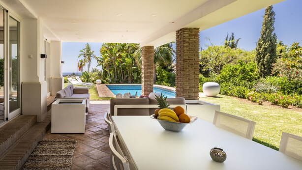 A modern outdoor patio with a pool, seating, and a fruit bowl on a table. -  Beautiful sunny villa with pool and sea views Marbella (ELVIRIA) (Marbella)