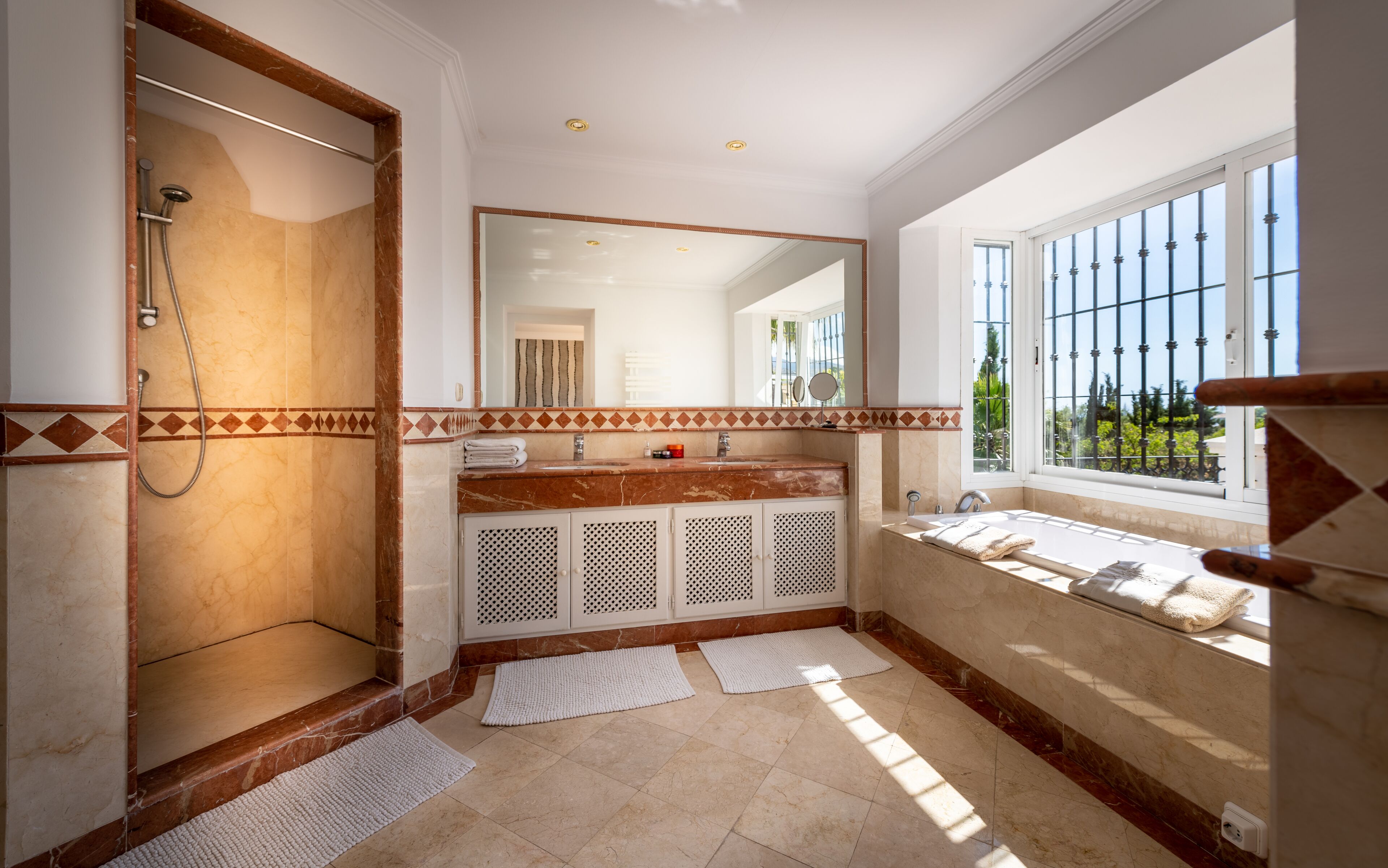 A bathroom with a shower, a sink, a bathtub, and a large window.