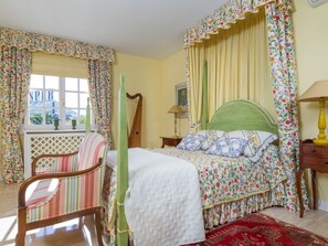A bedroom with a bed, a chair, a nightstand, a lamp, and a window with curtains. - Can Mandol - Spectacular luxury house with pool and large garden (Inca)